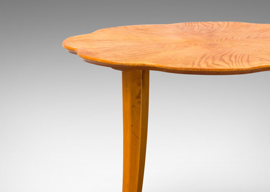 Gallery BAC ound top with lobed edge and radiating book-matched solid cuts and flared legs