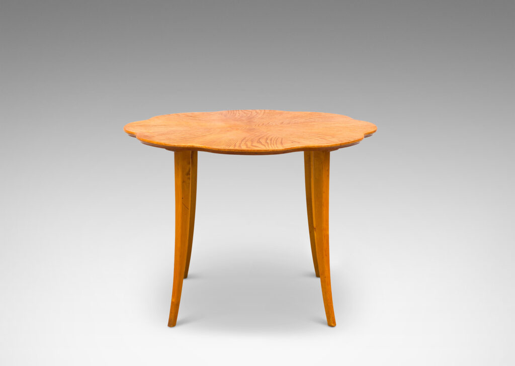 Gallery BAC ound top with lobed edge and radiating book-matched solid cuts and flared legs