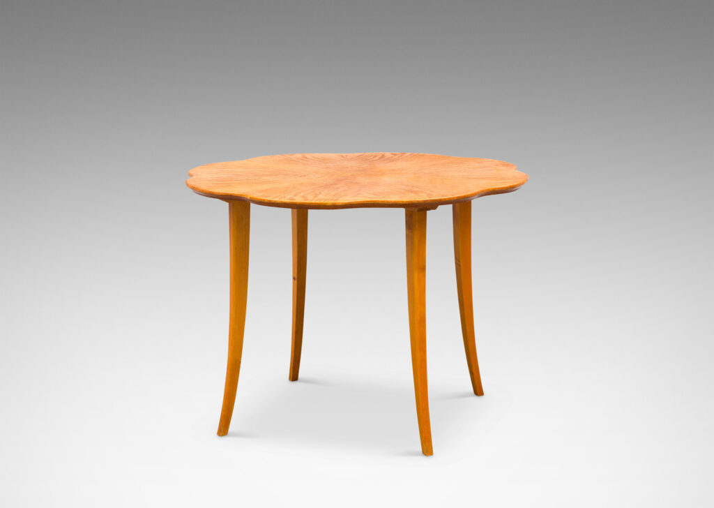 Gallery BAC ound top with lobed edge and radiating book-matched solid cuts and flared legs