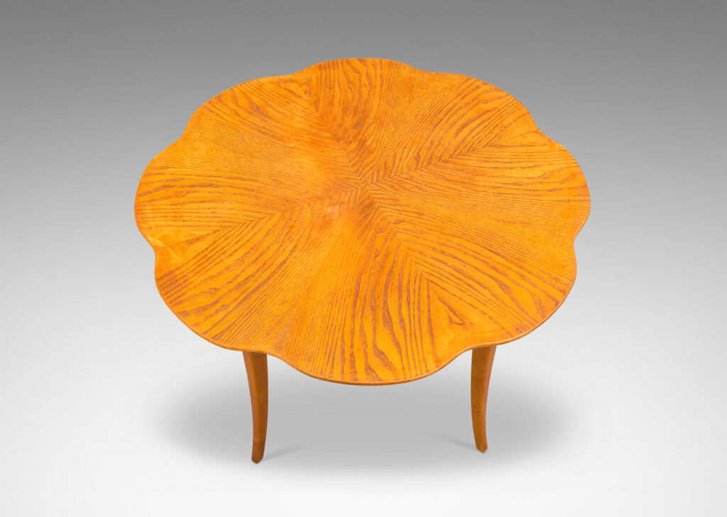 Gallery BAC ound top with lobed edge and radiating book-matched solid cuts and flared legs