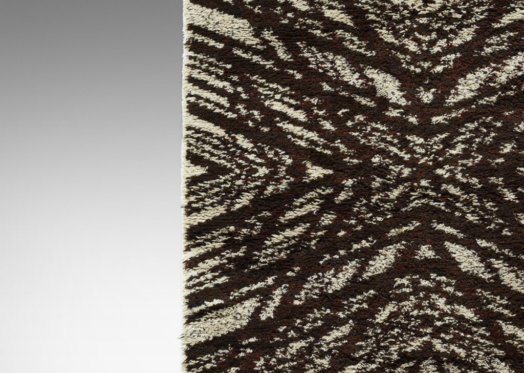 Gallery BAC Tigerfällen (Fallen Tiger) rya carpet with graphic pattern of radiating lines in brown on an ivory background