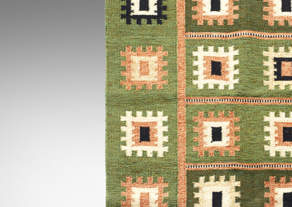 Gallery BAC Flat-weave carpet with folk-inspired pattern of notched squares in peach, ivory and black on a grass-green field, subdivided by linear elements