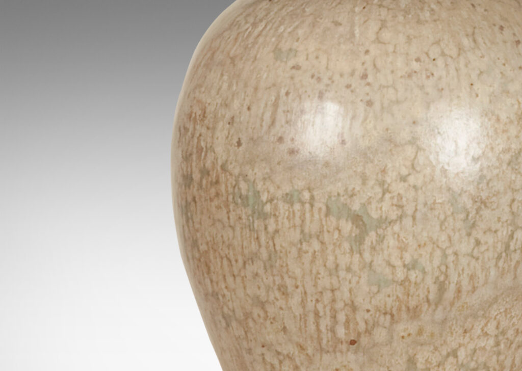 Gallery BAC flared oval bell form in stoneware masterfully glazed in softly dappled pale gray and sand tones, with patinated cast bronze base and collar with filigree details