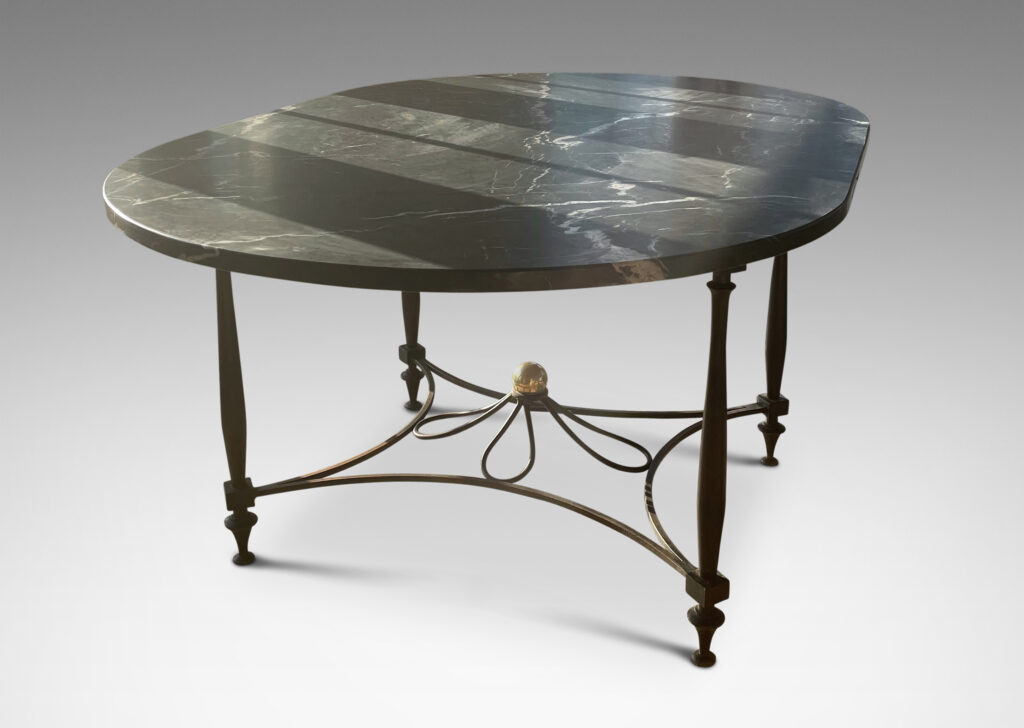 Gallery BAC iron base composed of sinuous baluster legs and concave arc stretchers connected by a rosette, with a spectacular oval top of figured gray marble