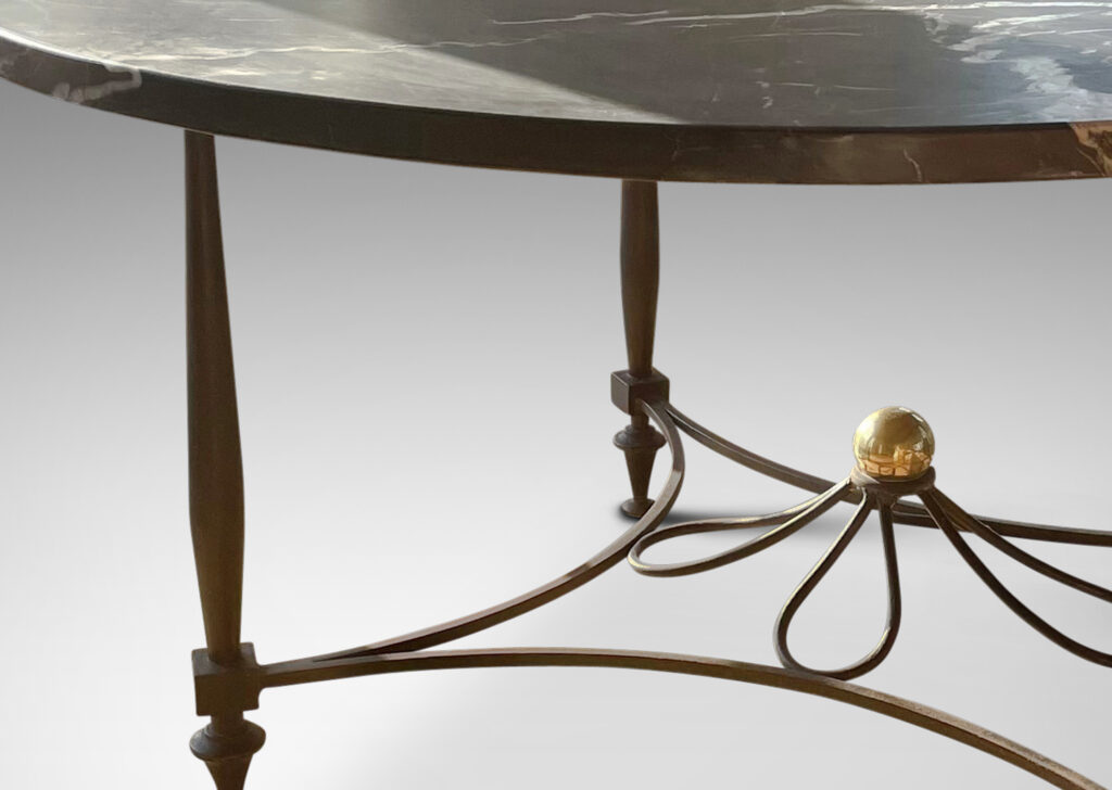 Gallery BAC iron base composed of sinuous baluster legs and concave arc stretchers connected by a rosette, with a spectacular oval top of figured gray marble