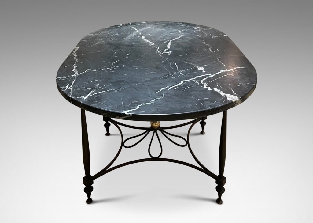 Gallery BAC iron base composed of sinuous baluster legs and concave arc stretchers connected by a rosette, with a spectacular oval top of figured gray marble