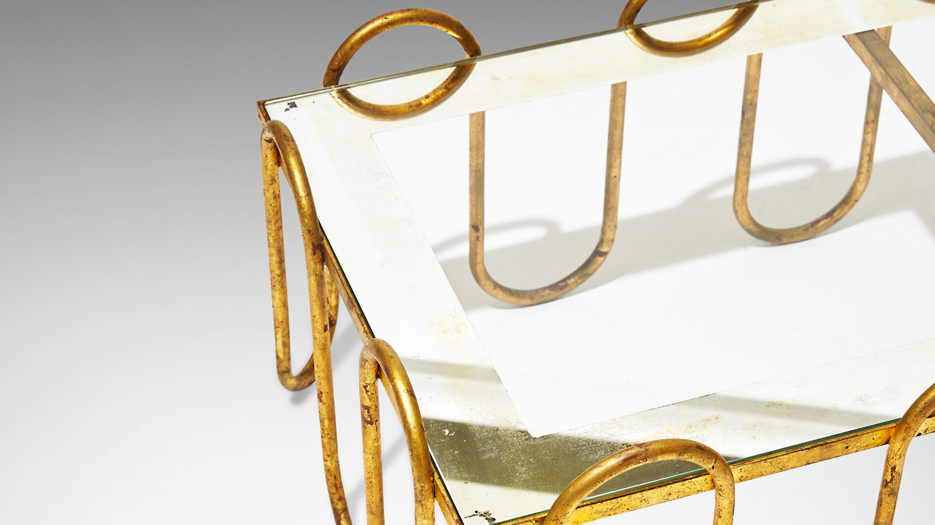 Gallery BAC waves in gilded iron forming the frame, with glass top edged with mirror backing