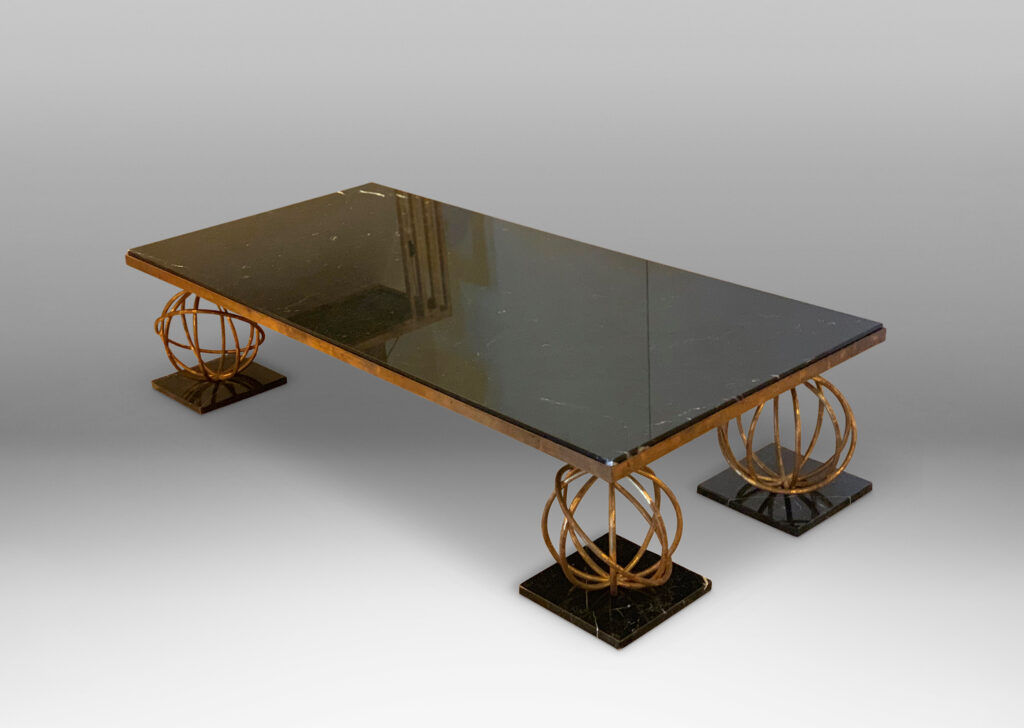 Gallery BAC coffee table by Jean Royère, having a rectangular black marble top supported on four “Sphère” motif legs