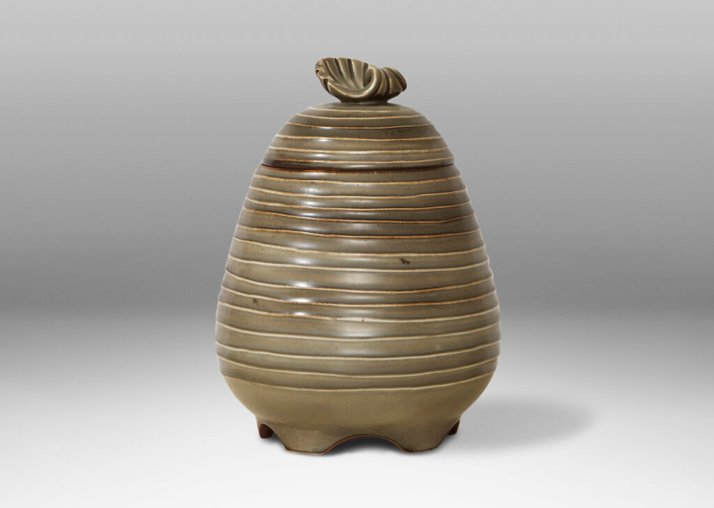 Gallery BAC Hand-thrown lidded jar with horizontal channels and shell ornament in stoneware with moody green glaze by Ebbe Sadolin