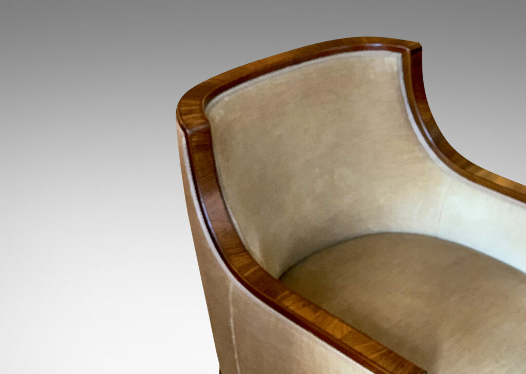 Gallery BAC club chairs, having curved backs with coved armrests, framed in a band of mahogany