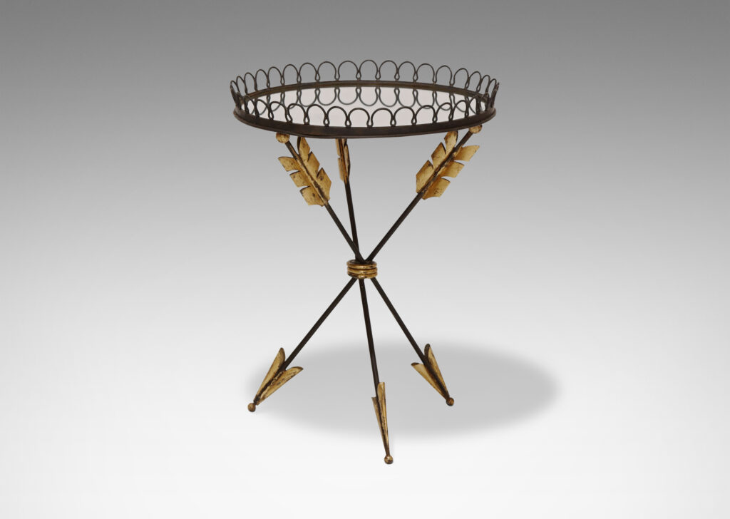 Gallery BAC tripod base in the form of three arrows joined at the center, supporting a round mirrored glass top edged in an airy looping border