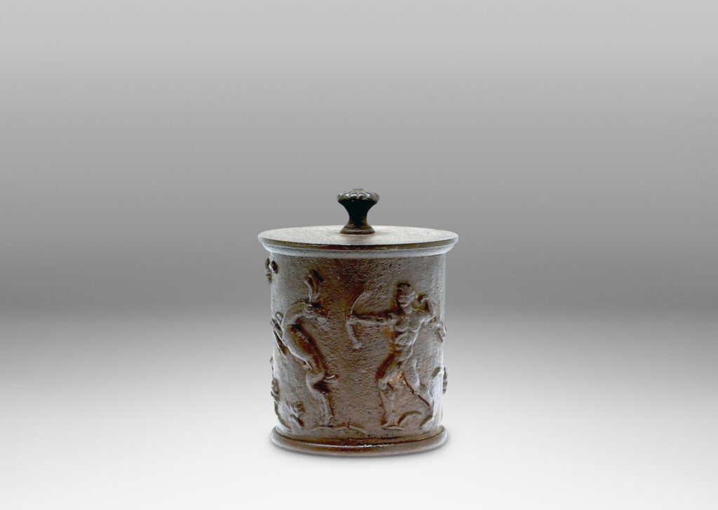 Gallery BAC ylindrical jar with a relief depicting the myth of Diana and Actaeon capped by a disk lid with rosette finial