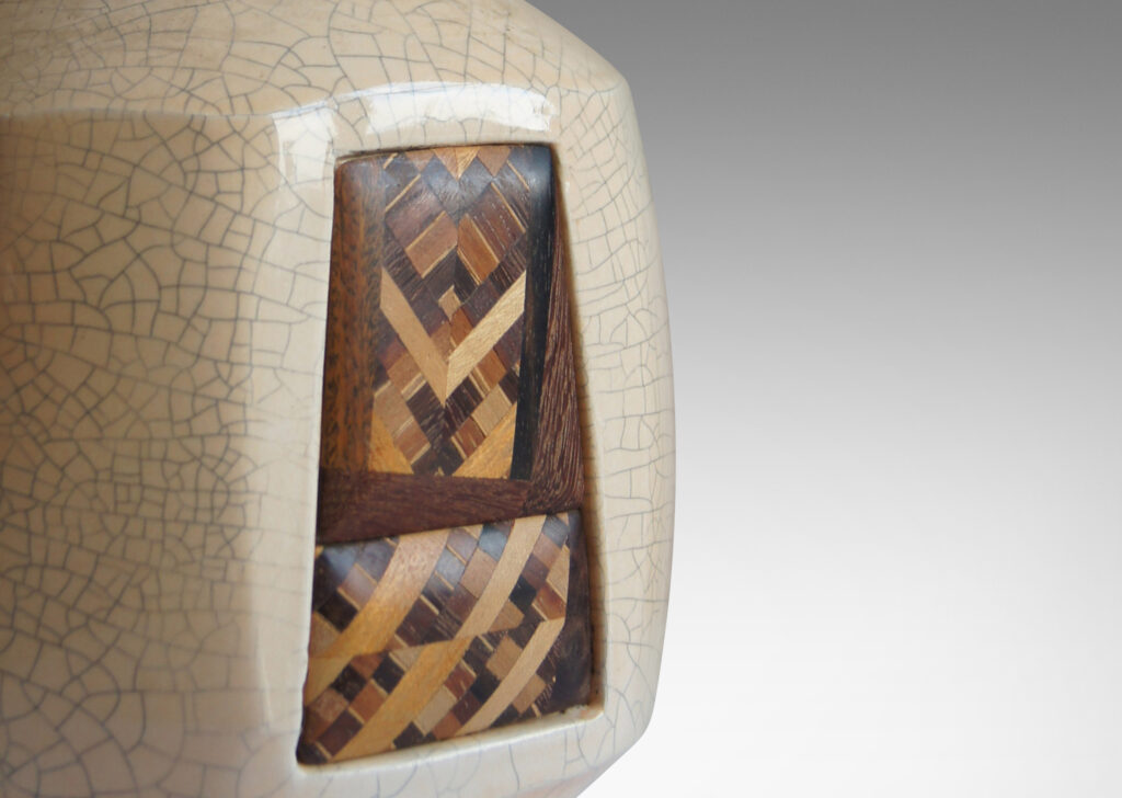 Gallery BAC geometric design inset into one of eight faces of an ivory craquelure-glazed globe form on a flanged foot