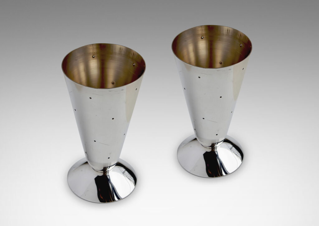 Gallery BAC combination vases / candlesticks each consisting of a conical form mounted to a modeled disk, which when set on the cone end is a candlestick with the disk functioning as a bobeche around a socket, and when set on the disk end is a vase