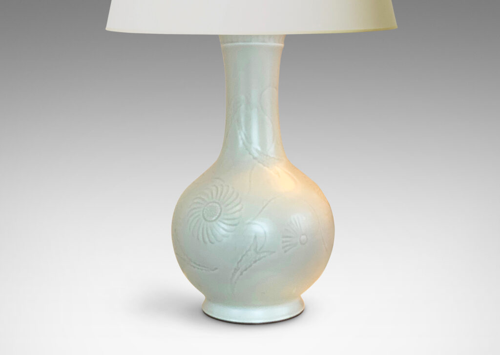 Gallery BAC spherical body with a flanged foot and flared neck, surrounded in a cheerful carved relief of stylized chrysanthemums; crafted in porcelain with an eggshell finish glaze