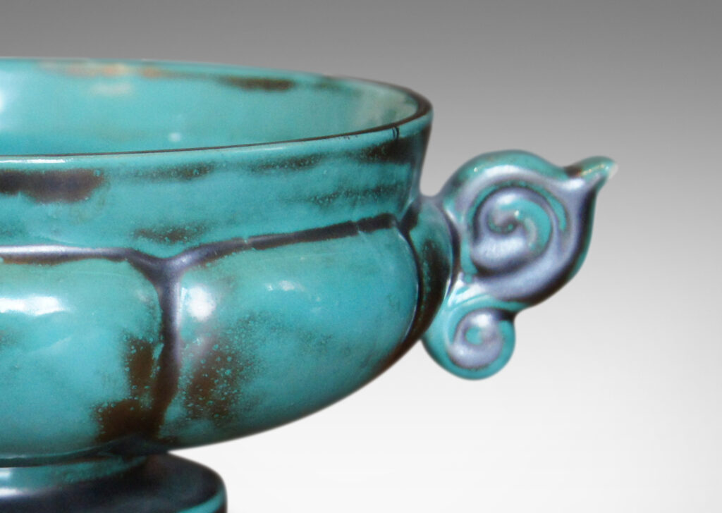 Gallery BAC blend of Viking, Chinese, and Art Deco influences, having wide lobed forms on small plinths and handles, faience with an aqua-green copper glaze