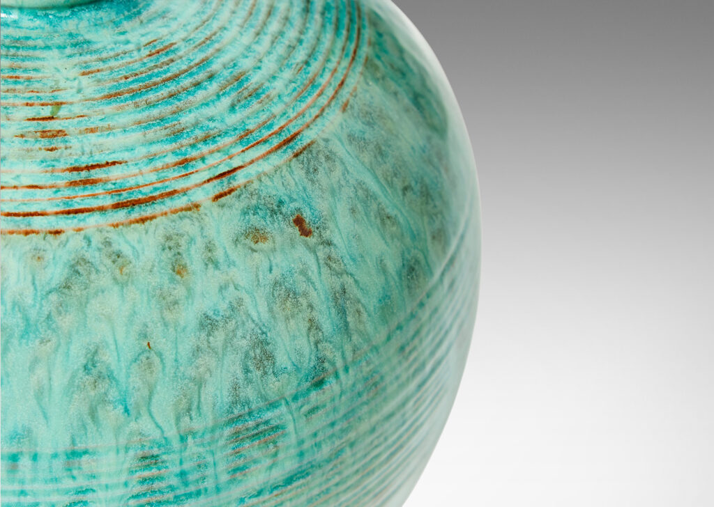 Gallery BAC wide globe form with bands of relief ridges and a flowing pale turquoise