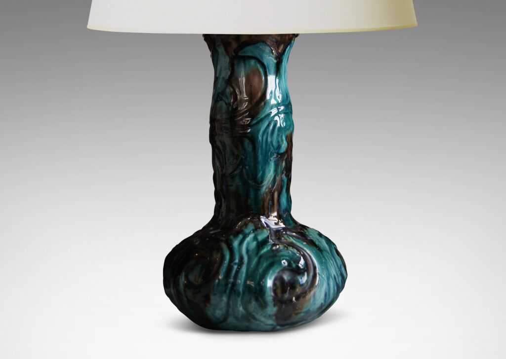 Gallery BAC decanter-like form with low wide body and tall neck, with carved swirling motifs in flowing teal and brown glazing