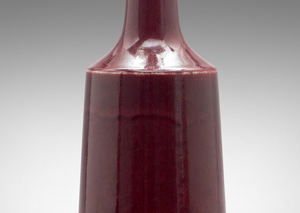 Gallery BAC angled bottle form in an oxblood glaze; stoneware