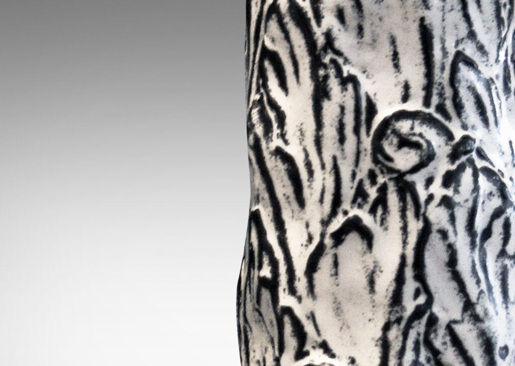 Gallery BAC columnar bases hand-carved with an energetic acanthus leaf pattern in deep relief, further articulated with a white-black tin glaze