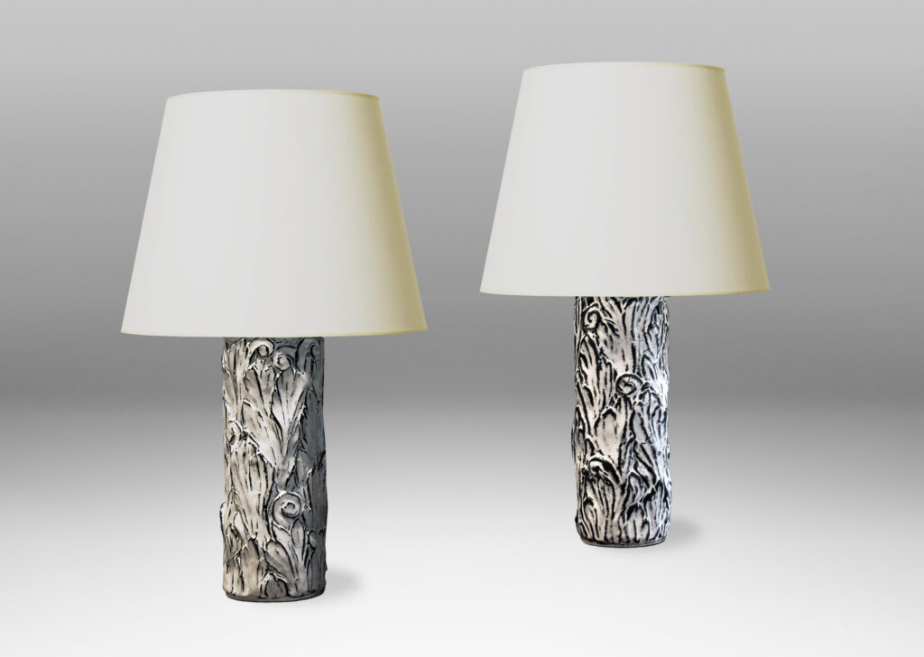 Gallery BAC columnar bases hand-carved with an energetic acanthus leaf pattern in deep relief, further articulated with a white-black tin glaze