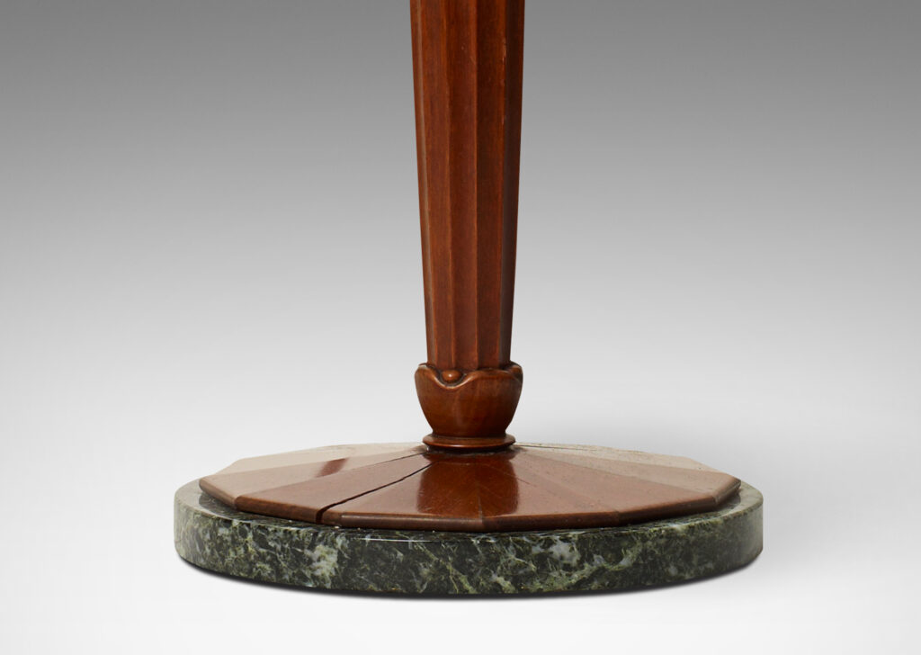 Gallery BAC base comprised of a lobed column capped with volutes, balanced on an ebonized wood sphere perched atop a round base sculpted in radiating planes mounted on a green marble disk