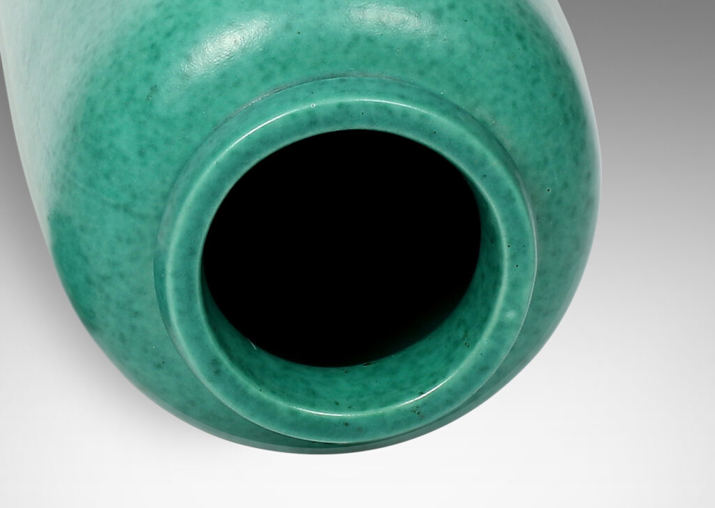 Gallery BAC cylindrical form with rounded ends, notched neck/mouth and tray stand in a mottled blue-green copper oxide glaze