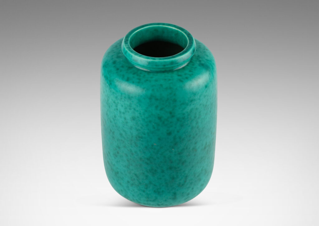 Gallery BAC rounded ends and notched neck/mouth and tray stand in a mottled blue-green copper oxide glaze