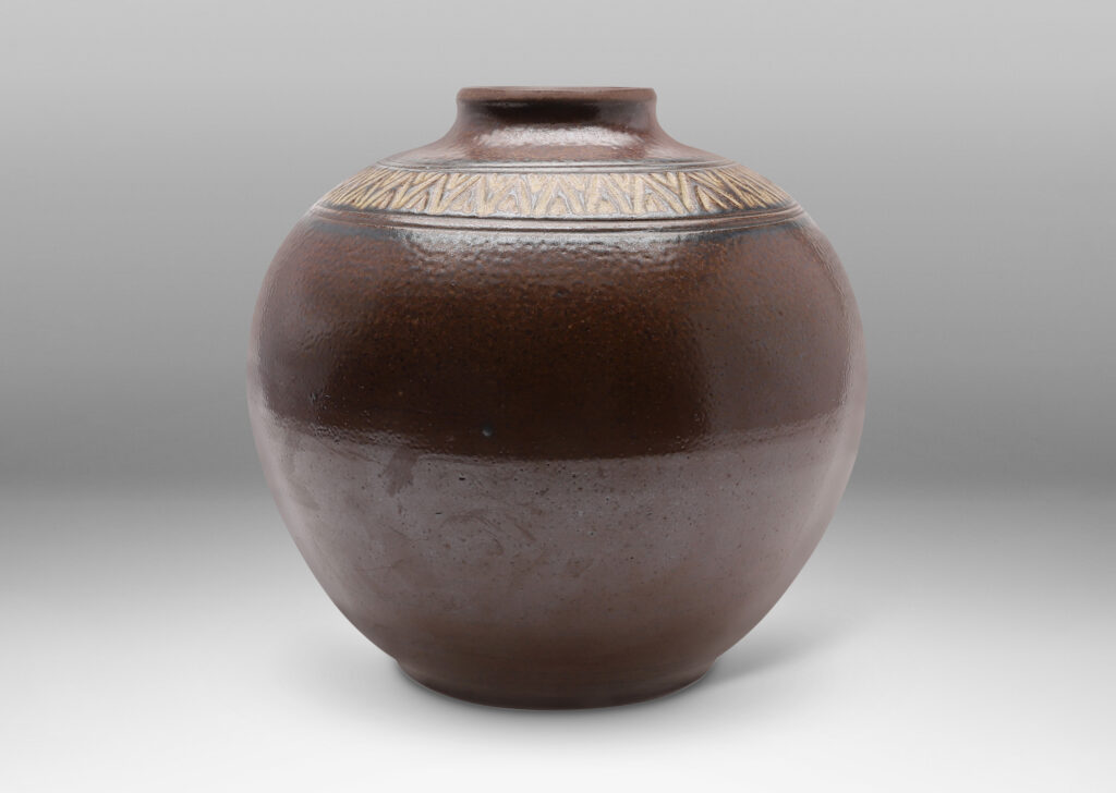 Gallery BAC wide globe form with carved collar of triangular motifs in a rich and rustic brown salt glaze