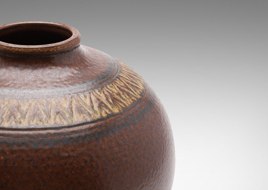 Gallery BAC wide globe form with carved collar of triangular motifs in a rich and rustic brown salt glaze