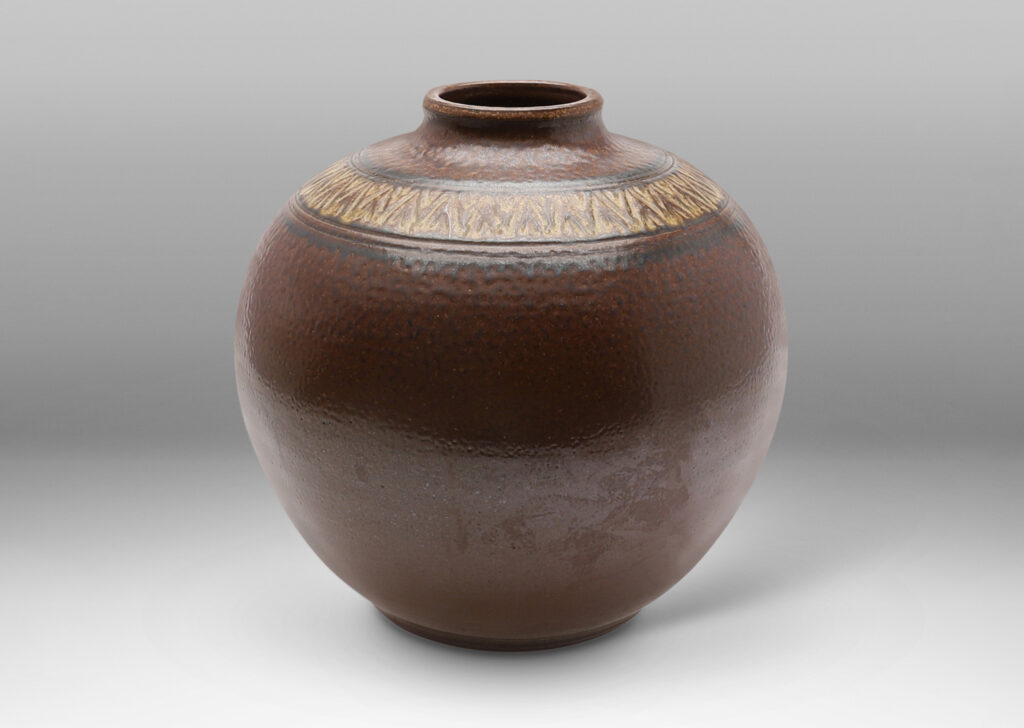 Gallery BAC wide globe form with carved collar of triangular motifs in a rich and rustic brown salt glaze