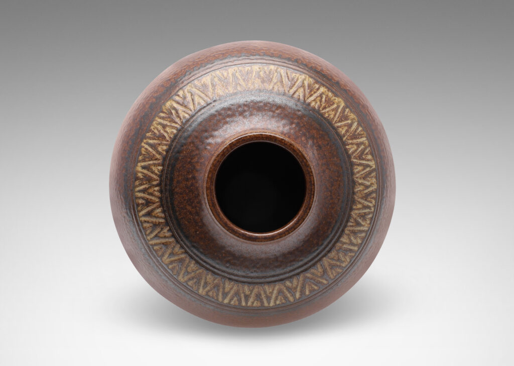 Gallery BAC wide globe form with carved collar of triangular motifs in a rich and rustic brown salt glaze