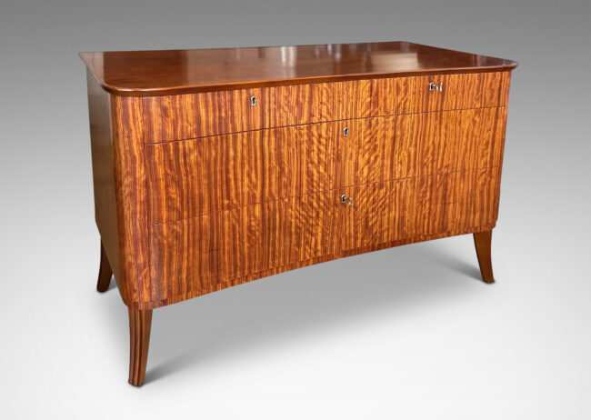 Gallery BAC organically modeled case and top with flared legs and five drawers, masterfully crafted with ribbon-cut mahogany veneers and solid mahogany frame and drawers