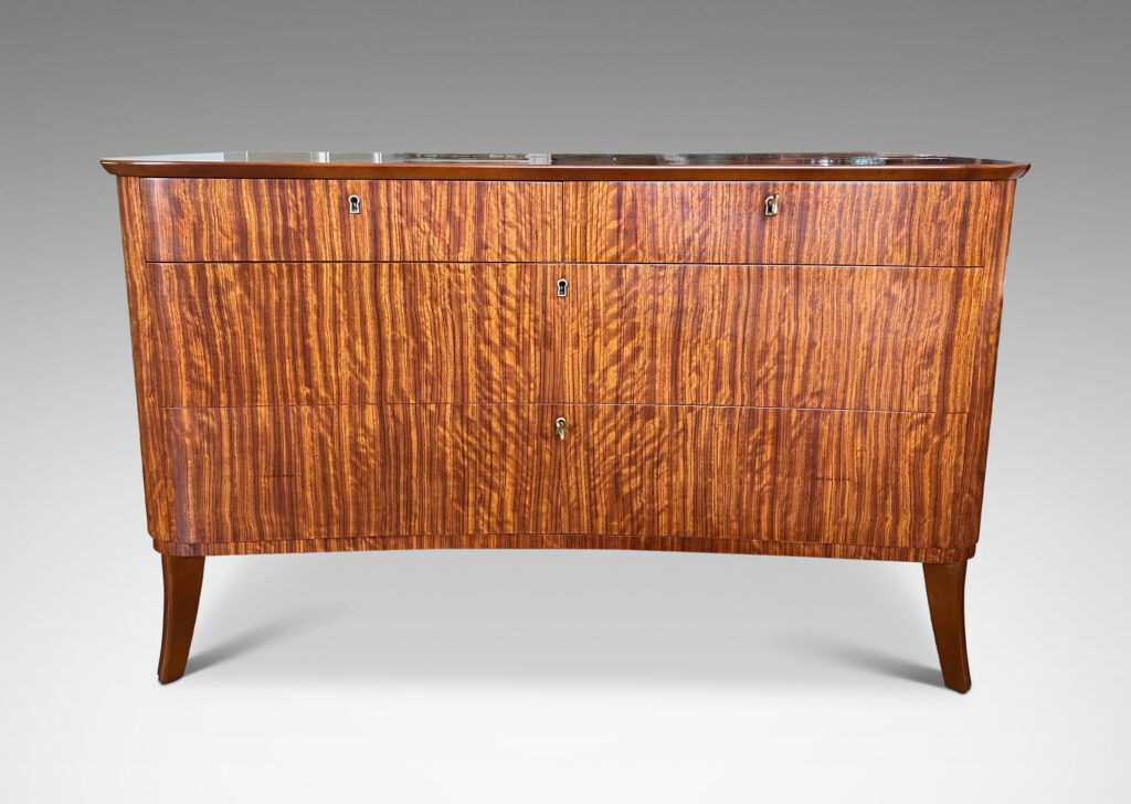 Gallery BAC organically modeled case and top with flared legs and five drawers, masterfully crafted with ribbon-cut mahogany veneers and solid mahogany frame and drawers