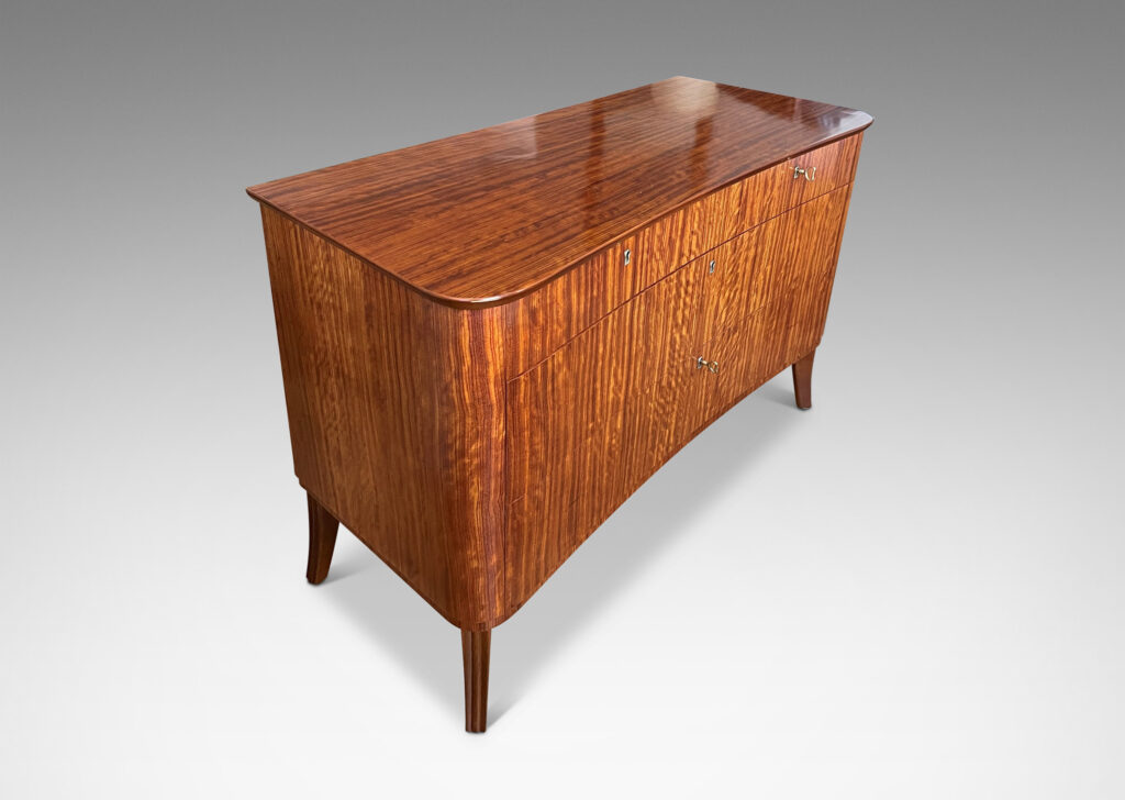 Gallery BAC organically modeled case and top with flared legs and five drawers, masterfully crafted with ribbon-cut mahogany veneers and solid mahogany frame and drawers