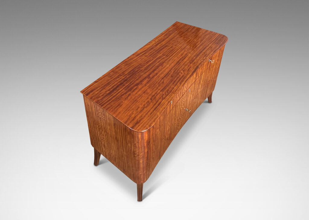 Gallery BAC organically modeled case and top with flared legs and five drawers, masterfully crafted with ribbon-cut mahogany veneers and solid mahogany frame and drawers