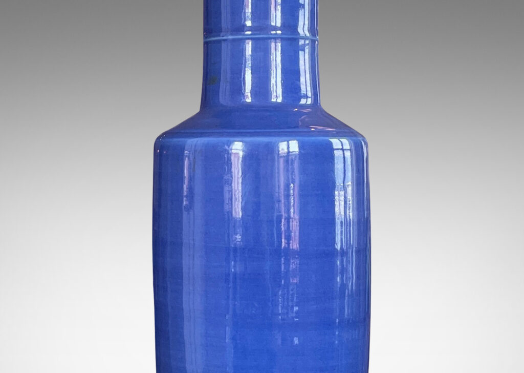 Gallery BAC tall rationalized vase forms in earthenware with a vibrant blue glaze and an ebonized wood mount