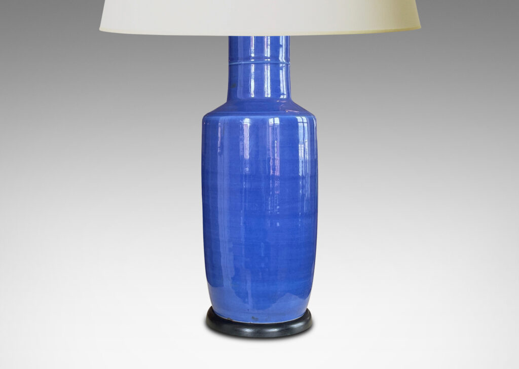 Gallery BAC tall rationalized vase forms in earthenware with a vibrant blue glaze and an ebonized wood mount