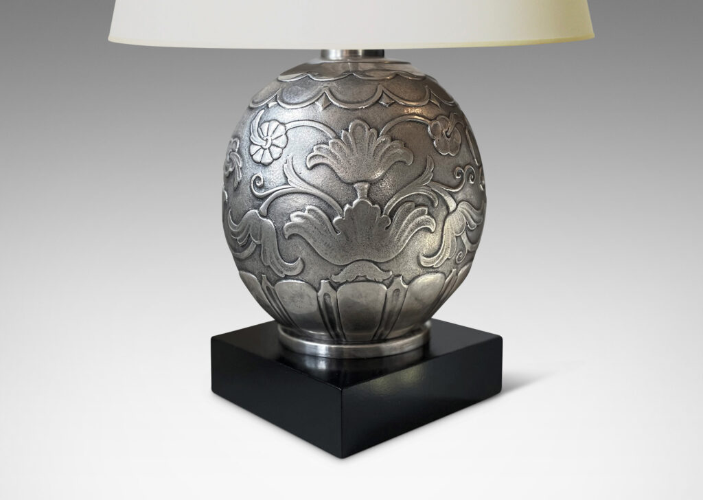 Gallery BAC silvered brass ovoid form surrounded in stylized leaves and flowers on an ebonized wood plinth