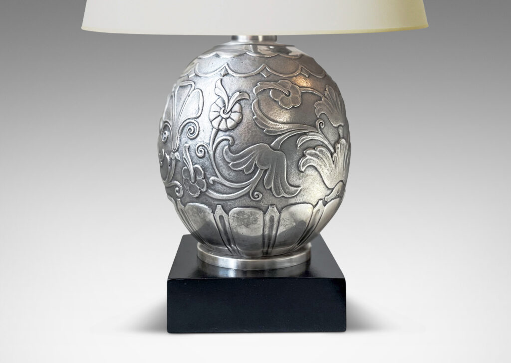 Gallery BAC silvered brass ovoid form surrounded in stylized leaves and flowers on an ebonized wood plinth