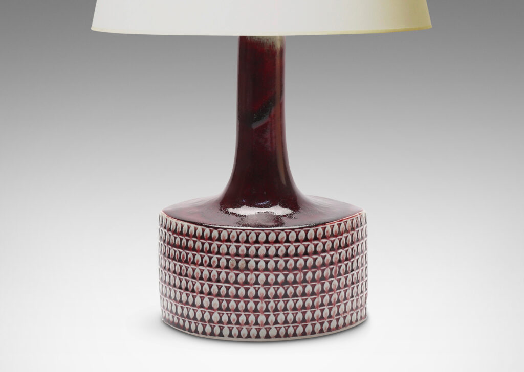 Gallery BAC football/ovoid drum form with registers of leaf motifs in relief and tall neck in a marvelous oxblood glaze