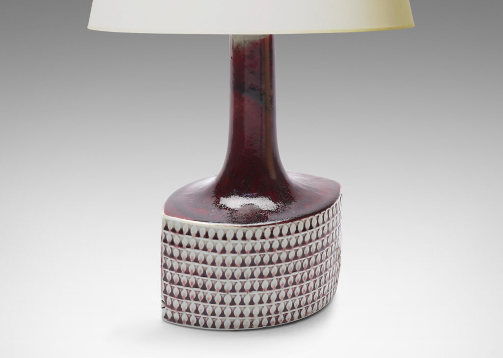 Gallery BAC football/ovoid drum form with registers of leaf motifs in relief and tall neck in a marvelous oxblood glaze