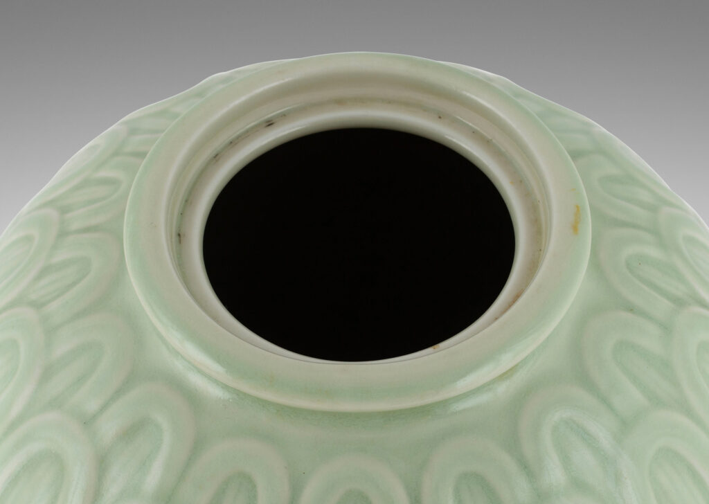 Gallery BAC ovoid form decorated with an overlapping scale pattern in relief and tassel finial on top, glazed in a very handsome pale celadon