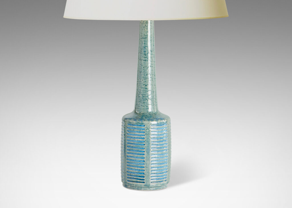 Gallery BAC cylindrical form with tall neck and pattern of carved rectangle motifs; glazed in muted pale olive green with turquoise accents