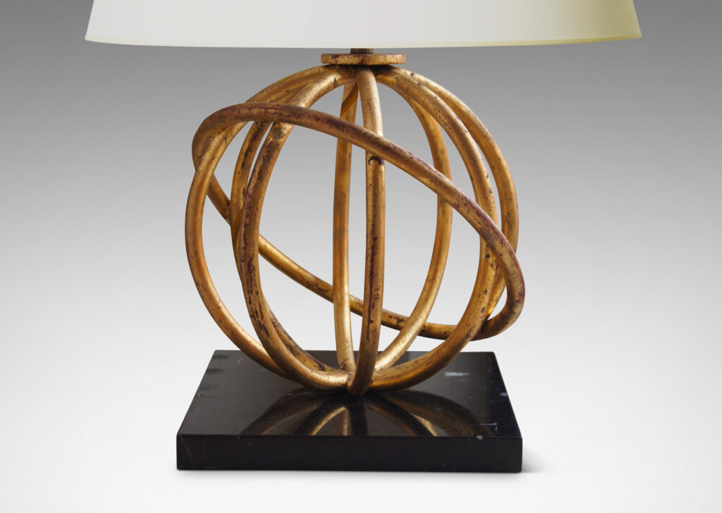 Gallery BAC globe formed by intersecting circles of gilded wrought iron mounted to a square plinth base in black marble