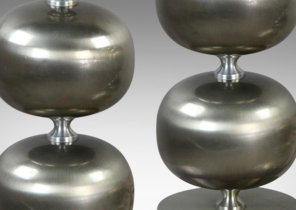 Gallery BAC bases of plump globe forms on a disk plinth in brushed steel with an iron weight