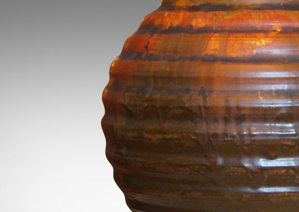 Gallery BAC a ridged globe form in flowing orange over brown glazing