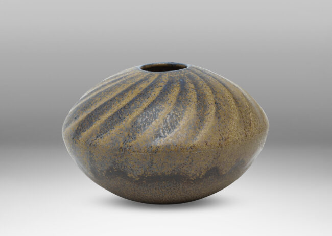 Gallery BAC discus form with carved swirling pattern, with a blue and light brown glaze