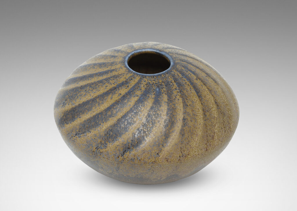 Gallery BAC discus form with carved swirling pattern, with a blue and light brown glaze