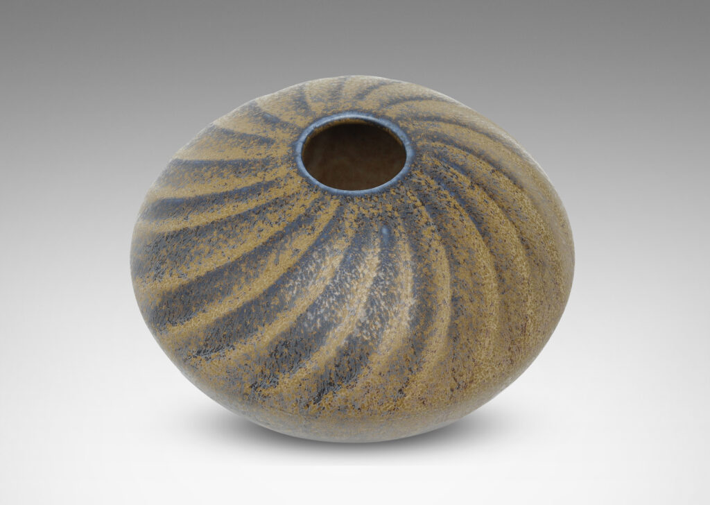 Gallery BAC discus form with carved swirling pattern, with a blue and light brown glaze